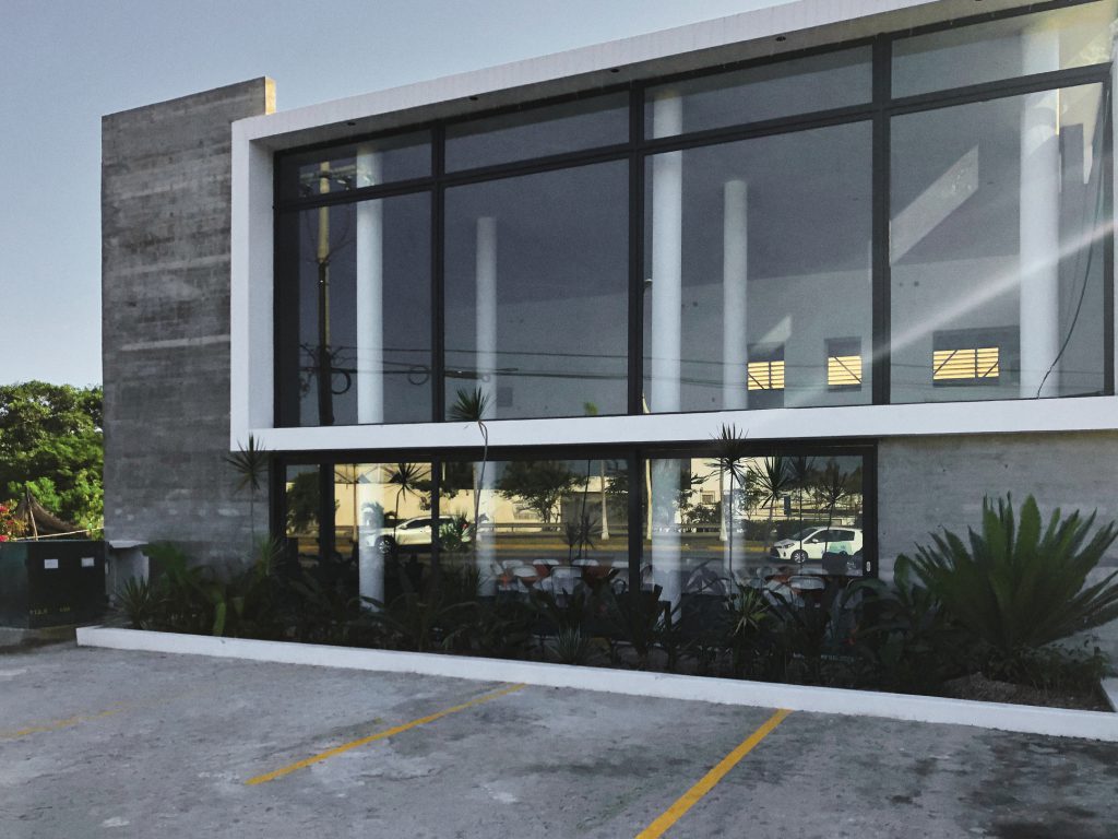 Fachada iluminada con ventanales de vidrio a la medida